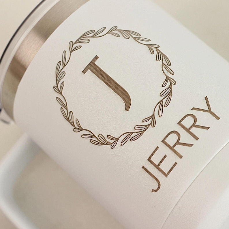 Puede incluir: Una taza de cer&aacute;mica blanca con un asa negra y el texto "But First, Coffee" en negrita negra. La taza est&aacute; sobre una superficie blanca. La taza mide 10 cm de alto.