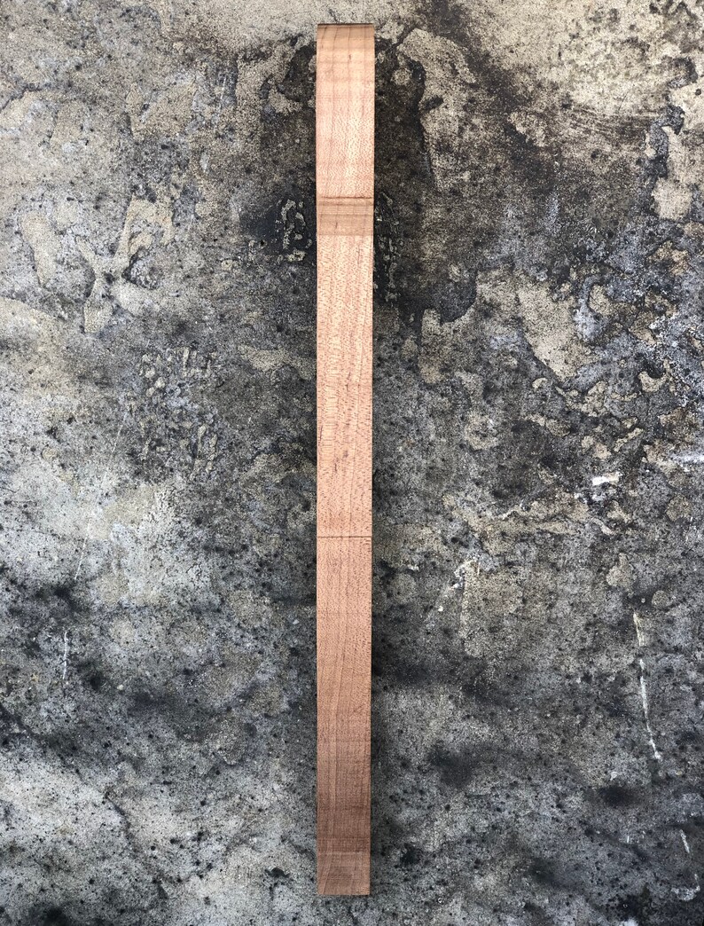 Peut inclure: Une longue et fine pi&egrave;ce de bois avec une finition naturelle. Le bois est lisse et de couleur brun clair.