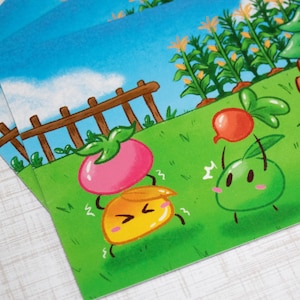May include: A colorful illustration of two cartoon fruit characters in a garden setting. The characters are a yellow fruit with a pink top and a green fruit with a red top. The background features a brick house with a green roof, a fence, and corn plants.