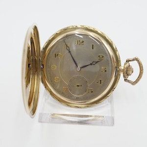 May include: A gold pocket watch with a white face and black hands. The watch has a decorative design around the edge of the face and a gold chain attached to the top.
