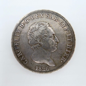 Puede incluir: Moneda de plata con el retrato de un hombre en un lado y el texto "SAR. FELIX. D.G. REX SAR. GYP. ET. HLER. 1826" en el otro.