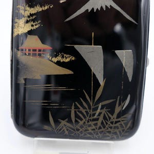 Könnte beinhalten: Schwarzes Lack-Zigarettenetui mit einem goldenen und silbernen Design eines Berges, eines Hauses und Bambus. Die Nummer 2035 ist auf einem weißen Etikett unter dem Etui aufgedruckt.