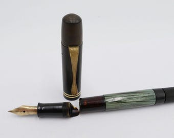 Pluma estilográfica PELIKAN 100 de 30 piezas con sistema de llenado por pistón, plumín de oro de 14 quilates, color verde y negro a rayas, 585