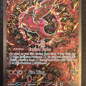 May include: A Pokémon trading card featuring Oricorio EX. The card has a fiery red and orange background with a stylized bird illustration. Text includes "Excited Turbo" and "Fire Wing".