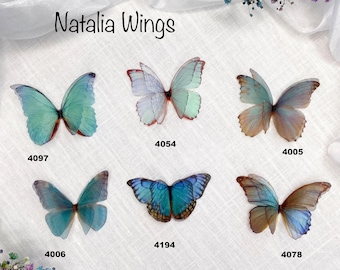 May include: Six butterfly wings in various colors, including blue, green, and white. The wings are arranged in two rows of three, with the numbers 4097, 4006, 4078, 4054, 4194, and 4005 written below each wing. The text "Natalia Wings" is written at the top of the image.