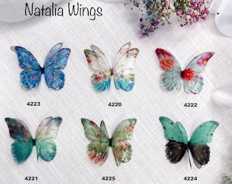 May include: Six butterfly wings with different patterns and colors. The wings are made of sheer fabric and have a delicate, ethereal look. The wings are labeled with numbers 4223, 4220, 4222, 4221, 4225, and 4224.