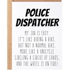 May include: A white card with black text that reads "POLICE DISPATCHER" and a humorous description of the job: "MY JOB IS EASY. IT'S LIKE RIDING A BIKE. BUT NOT A NORMAL BIKE. MORE LIKE A UNICYCLE CIRCLING A CIRCUS OF CHAOS, AND THE WHEEL IS ON FIRE!"