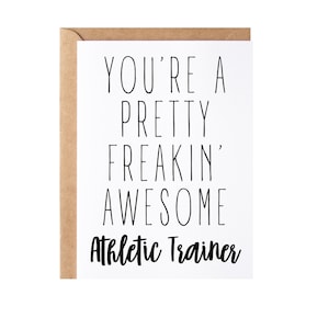 May include: A white card with black text that reads "You're a pretty freakin' awesome Athletic Trainer". The card has a brown envelope.