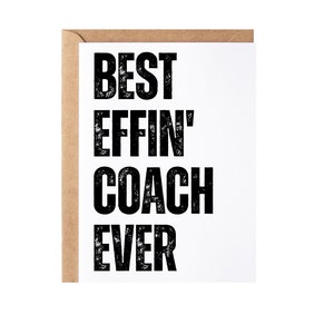 May include: A white card with black text that reads "BEST EFFIN' COACH EVER". The card is on a brown envelope.