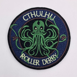 May include: A round, dark blue and brown embroidered patch with a green Cthulhu monster in the center. The text "Cthulhu Roller Derby" is embroidered around the monster.