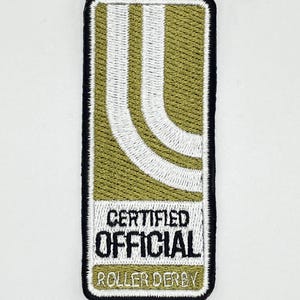 May include: A green and white embroidered patch with the text "CERTIFIED OFFICIAL ROLLER DERBY".