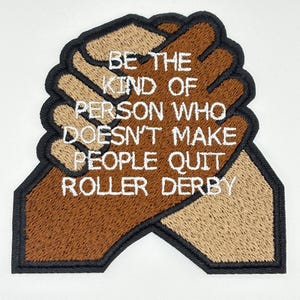 May include: Embroidered patch featuring two clasped hands in shades of brown and tan, outlined in black. The patch reads "BE THE KIND OF PERSON WHO DOESN'T MAKE PEOPLE QUIT ROLLER DERBY" in white.