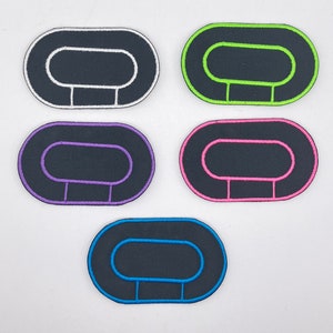May include: Five felt oval patches with white stitching around the edges. The patches are black with white stitching, green with white stitching, pink with white stitching, purple with white stitching, and blue with white stitching.