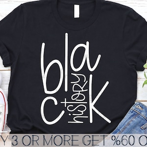 Peut inclure: T-shirt noir avec un texte blanc qui dit "Black History" avec les lettres "bla" et "k" empilées l'une sur l'autre. Le texte est dans une police d'écriture de style manuscrit.