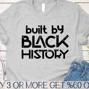 May include: A grey t-shirt with black text that reads "built by BLACK HISTORY".