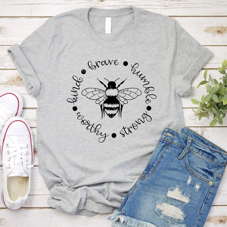May include: Grey t-shirt with a black bee graphic and the words "brave", "humble", "kind", "worthy", and "strong" in a circle around the bee.