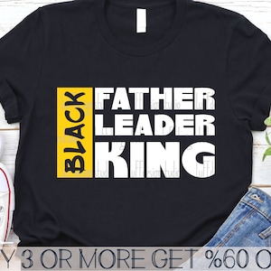 May include: Black t-shirt with the words "BLACK FATHER LEADER KING" in yellow and white lettering.