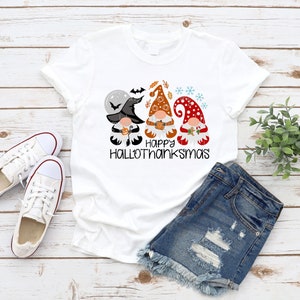May include: White t-shirt with a graphic of three gnomes wearing hats and holding pumpkins. The text "Happy Hallothanksmas" is printed below the gnomes.