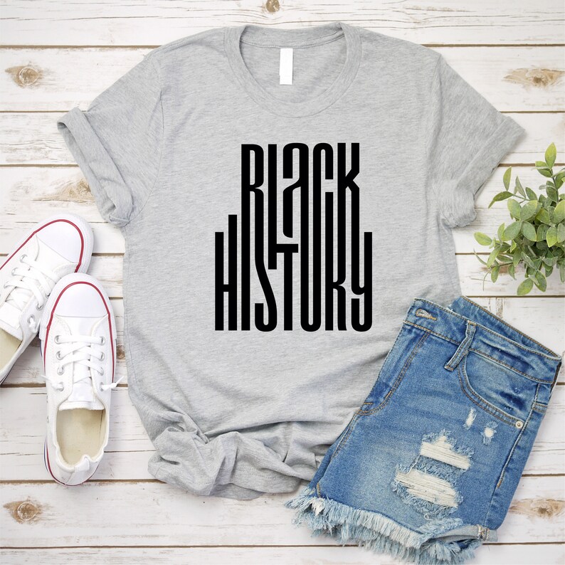 May include: A gray t-shirt with the text "BLACK HISTORY" printed in black letters.