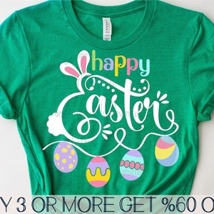 May include: Green t-shirt with a white bunny and the text "Happy Easter" in rainbow colors.  The bunny is holding a string of colorful Easter eggs.  The text "BUY 3 OR MORE GET %60 OFF" is at the bottom of the shirt.
