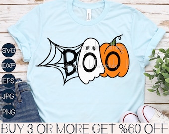 May include: A light blue t-shirt with a black and white graphic of a ghost and a pumpkin with the word "BOO" in black letters. The graphic is on a white spiderweb.