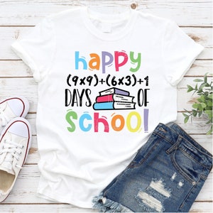 May include: White t-shirt with a colorful graphic that says "happy (9x9)+(6x3)+1 days of school!" with a stack of colorful books.