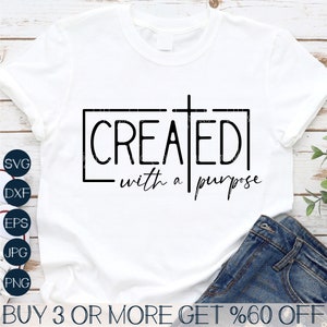 Puede incluir: Camiseta blanca con un gráfico negro que dice "CREATED with a purpose" y una cruz en el medio de la palabra "CREATED".