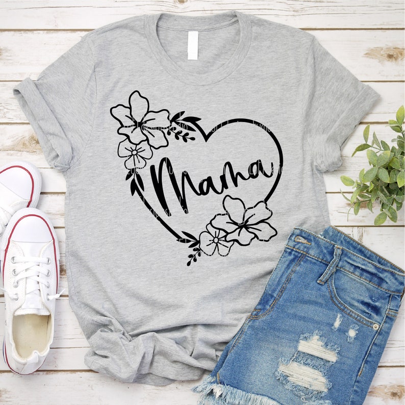 K&ouml;nnte beinhalten: Graues T-Shirt mit einem schwarzen Herzdesign, in dem "Mama" steht. Das Herz ist von schwarzen floralen Designs umgeben.