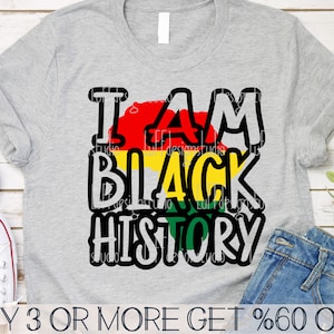 May include: A gray t-shirt with the text "I AM BLACK HISTORY" in black outlined letters. The text is layered over a red, yellow, and green graphic that resembles the Pan-African flag.