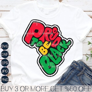 May include: A white t-shirt featuring a graphic design of the words "Proud to be Black" in red, yellow, and green. The graphic is shaped like the continent of Africa.