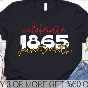 May include: A black t-shirt with the text "celebrate 1865 Juneteenth" in red and gold lettering. The text is in a handwritten style font.