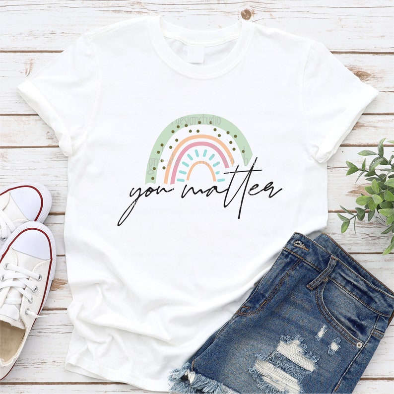 May include: White t-shirt with a rainbow design and the text "you matter" in black.