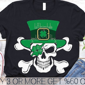 May include: A black t-shirt with a white skull wearing a green leprechaun hat with a shamrock on it. The skull has a green shamrock covering one eye. The skull is surrounded by two white bones. The text "BUY 3 OR MORE GET %60 OFF" is at the bottom of the image.