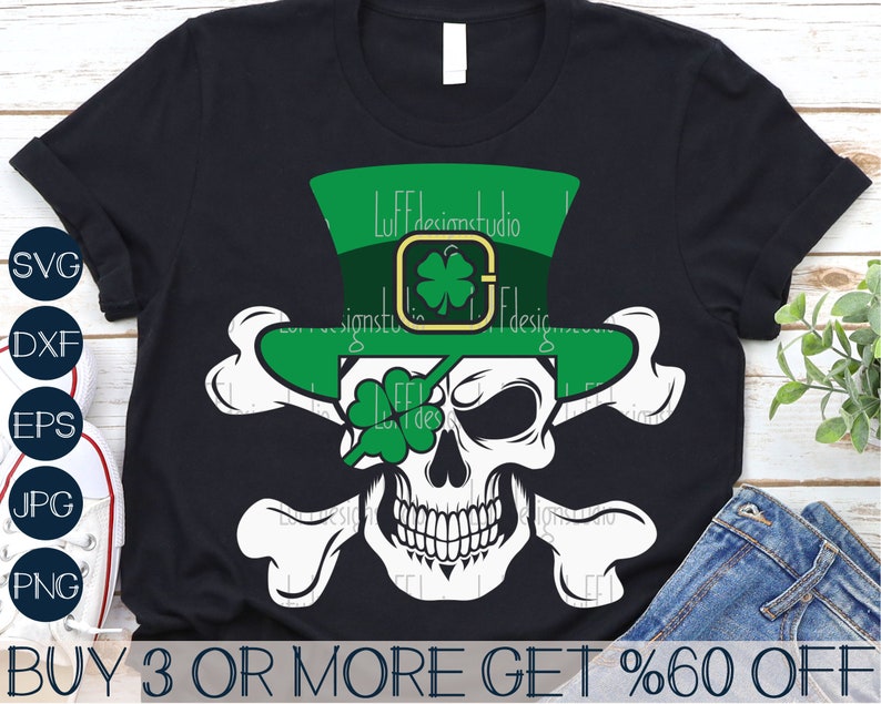 May include: A black t-shirt with a white skull wearing a green leprechaun hat with a shamrock on it. The skull has a green shamrock covering one eye. The skull is surrounded by two white bones. The text "BUY 3 OR MORE GET %60 OFF" is at the bottom of the image.