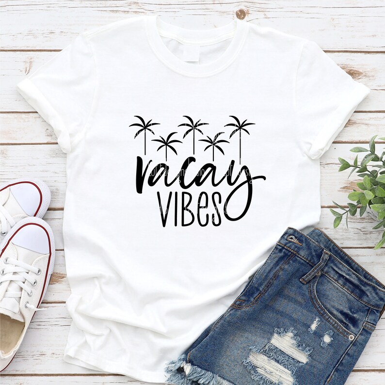 May include: White t-shirt with a black graphic of palm trees and the text "vacay vibes".