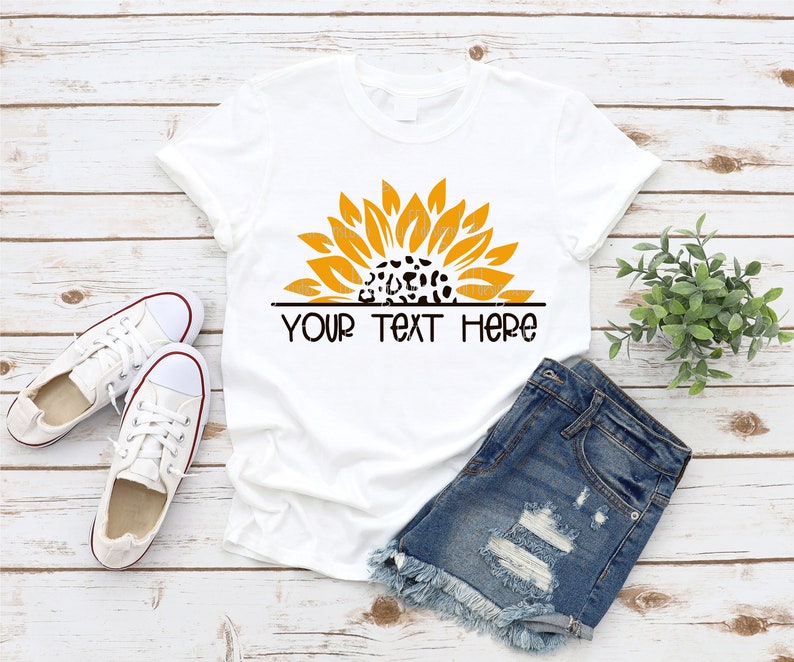 May include: White t-shirt with a yellow sunflower design with a leopard print center. The text "YOUR TEXT HERE" is printed below the sunflower.