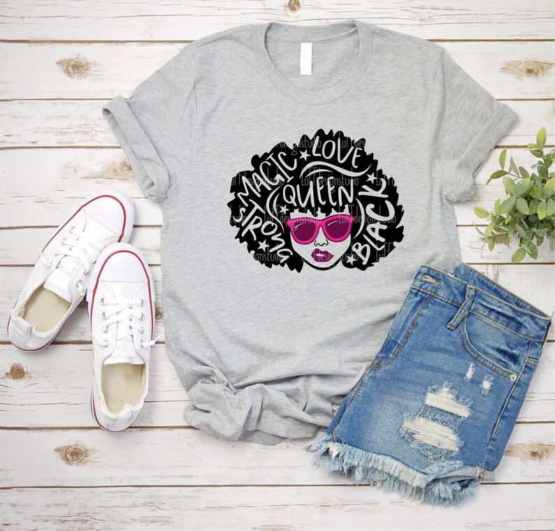 May include: Gray t-shirt with a black and white graphic of a woman with an afro. The graphic includes the words "Magic", "Strong", "Queen", "Love", and "Black".