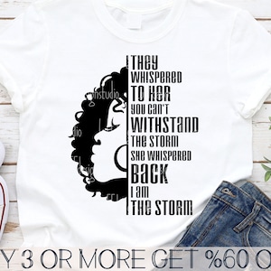 Peut inclure: Un t-shirt blanc avec une silhouette noire de la tête d'une femme et le texte "They whispered to her you can't withstand the storm she whispered back I am the storm".