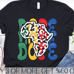 以下が含まれることがあります： カラフルなグラフィックデザインが施された黒いTシャツ。デザインは、ヒョウ柄のスタイリッシュなアフリカ大陸のアウトラインを特徴としています。「Peace」と「Love」の文字は、緑、黄色、青で書かれています。