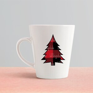 May include: White ceramic mug with a black and red plaid Christmas tree design.