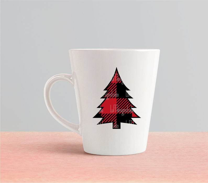 May include: White ceramic mug with a black and red plaid Christmas tree design.