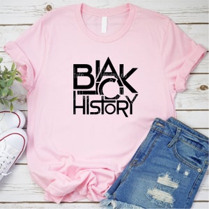 K&ouml;nnte beinhalten: Rosa T-Shirt mit einer schwarzen Grafik, auf der in fetter, blockiger Schrift "BLACK HISTORY" steht.