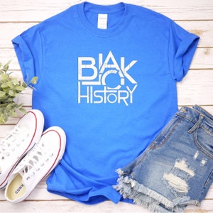 K&ouml;nnte beinhalten: Ein k&ouml;nigsblaues T-Shirt mit einem wei&szlig;en Grafikdesign, auf dem in einer stilisierten Schrift "BLACK HISTORY" steht.