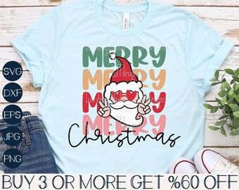May include: Light blue t-shirt with a colorful graphic featuring the words "MERRY Christmas" and a Santa Claus design. The Santa Claus is wearing sunglasses and making a peace sign. The shirt also has SVG, DXF, EPS, JPG, and PNG icons.
