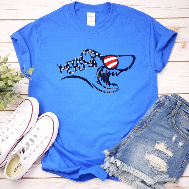 May include: A blue t-shirt with a shark silhouette wearing sunglasses. The shark's body is made up of the word "MERICA" with stars and stripes.