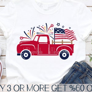 May include: Red pickup truck with a wooden bed carrying an American flag and fireworks. The truck is on a white t-shirt with the text "BUY 3 OR MORE GET %60 OFF".