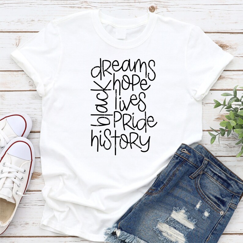 May include: White t-shirt with black text that reads "dreams hope black lives pride history".
