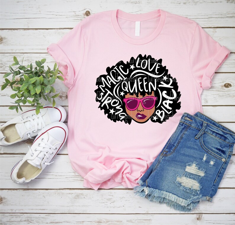 May include: Pink t-shirt with a black and white graphic of a woman with an afro. The graphic includes the words "Magic", "Love", "Queen", "Strong", and "Black".