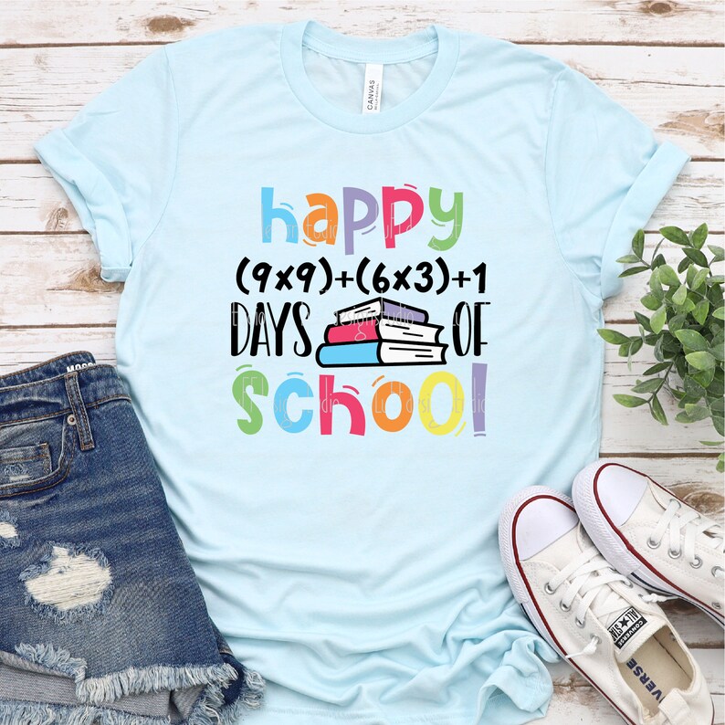 May include: A light blue t-shirt with the text "happy (9x9)+(6x3)+1 DAYS OF school!" in colorful letters. The text is layered over a stack of colorful books.