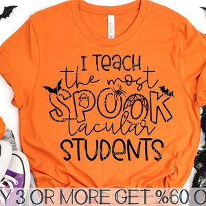 May include: Orange t-shirt with black text that reads "I teach the most spooktacular students". The text is decorated with bats, ghosts, and spiderwebs.